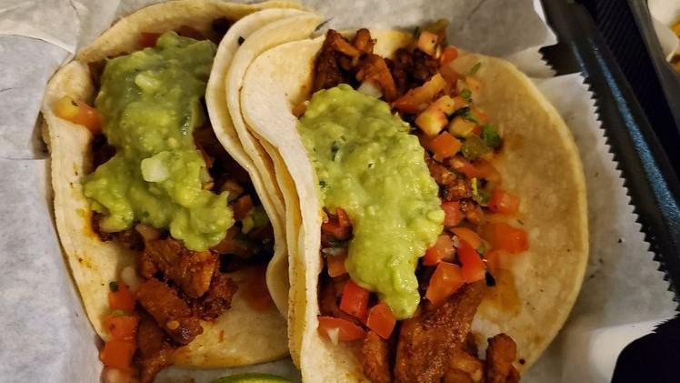 Pastor Taco · Marinated pork strips, seasoned and grilled, then topped with guacamole, and pico de gallo.