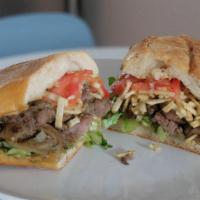 Pan Con Bistec · Seared palomilla steak with onions, lettuce, tomato & shoestring potatoes on pressed Cuban b...