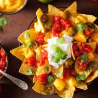 Macho Nachos · Delicious crispy nachos topped with melted cheese, ground beef, refried beans, green chilli ...