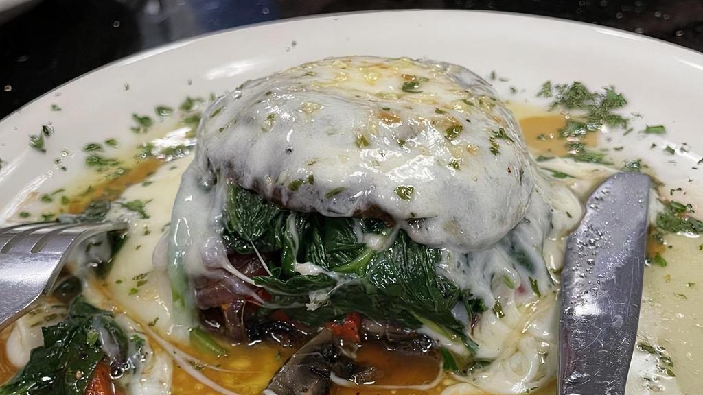 Roasted Portabello · A roasted portabello mushroom stuffed with sauteed spinach, roasted peppers, and caramelized onions, topped with mozzarella cheese, and drizzled with garlic butter.