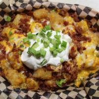 Loaded Tater Tots · Basket of golden tots loaded with bacon, cheese, green onions and sour cream.