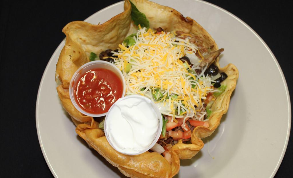 Taco Salad · Choice of seasoned ground beef, shredded chicken or shredded pork in a large crispy tortilla shell, fresh romaine, tomato, onions, olives, shredded cheese served with salsa and sour cream on the side.