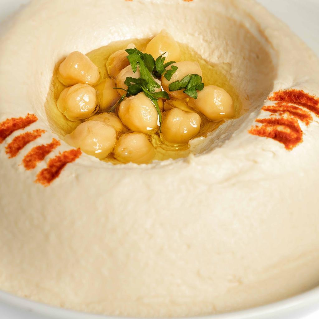 Hummus · Vegan. Chickpeas with tahini and lemon. Served with pita bread and assorted vegetables.