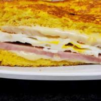 Montecristo Sandwich · Swiss cheese, turkey ham, and fried eggs on a french toast topped with powder sugar and a si...