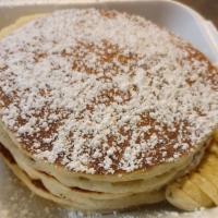 Macadamia Nut Pancake · Macadamia nuts cooked inside three fluffy pancakes.  Served with sliced bananas and a sprink...