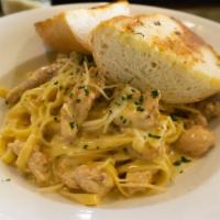 Chicken Fettuccine Alfredo · Pan seared tender chicken breast on a bed of fettuccine noodles tossed with broccoli, sautée...