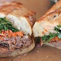 Brisket Banh Mi · Brisket with cucumber, jalapeno, cilantro, pickled carrots and sriracha mayo on a french roll.