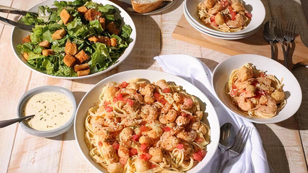 New!  Family Bundle Scampi Pasta Shrimp & Scallops · Tender Bay Scallops, hand-harvested off the Baja coast, tossed with roasted shrimp in a garlic scampi sauce, topped with fresh tomatoes over linguini. Includes salad, cookies and fresh bread. Feeds 4-5.