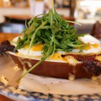 Breakfast Mac · Mac-n-cheese, candied bacon crust, two sunny side up fried eggs, lopped with dressed arugula.
