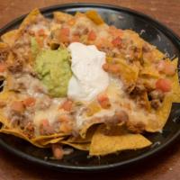 Super Nachos · Crisp corn tortilla chips, topped with refried beans, choice of either chicken or ground bee...