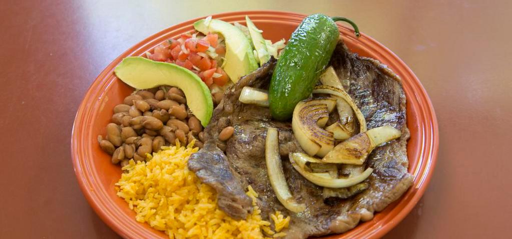 Carne Asada Plate · A generous portion of thin sliced beef steak, grilled to perfection, and served with grilled onions, fried jalapeño, guacamole rice, and beans.