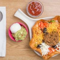 Taco Salad · Fried flour tortilla filled with iceberg lettuce, topped with seasoned ground beef, black ol...