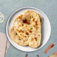 Bustin' Naan · A traditional Indian flatbread made with refined flour and baked in a tandoor oven.