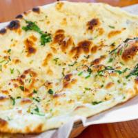 Garlic Naan · Naan with a subtle touch of garlic. Baked in a clay oven with mesquite charcoal.
