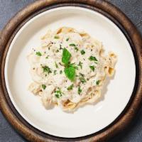 Alfredo In White Fettuccine  · Fettuccine pasta cooked in creamy white sauce topped with parmesan.