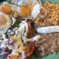 Chilaquiles Con Huevo · 2 eggs, chips with red or green salsa, Mexican cheese, onions, cilantro, sour cream rice, an...