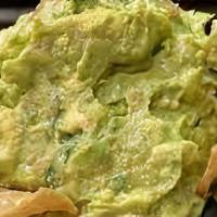 Guacamole · A corn tortilla bowl filled with Guacamole salad, tostadas and hot sauce on the side.