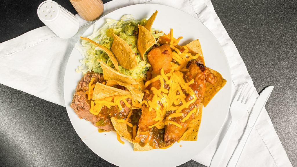 Chili Relleno Plate · Two chili rellenos on a bed of tostadas, refried beans all smothered with green chile and cheese. Garnished with guacamole and tostada chips.