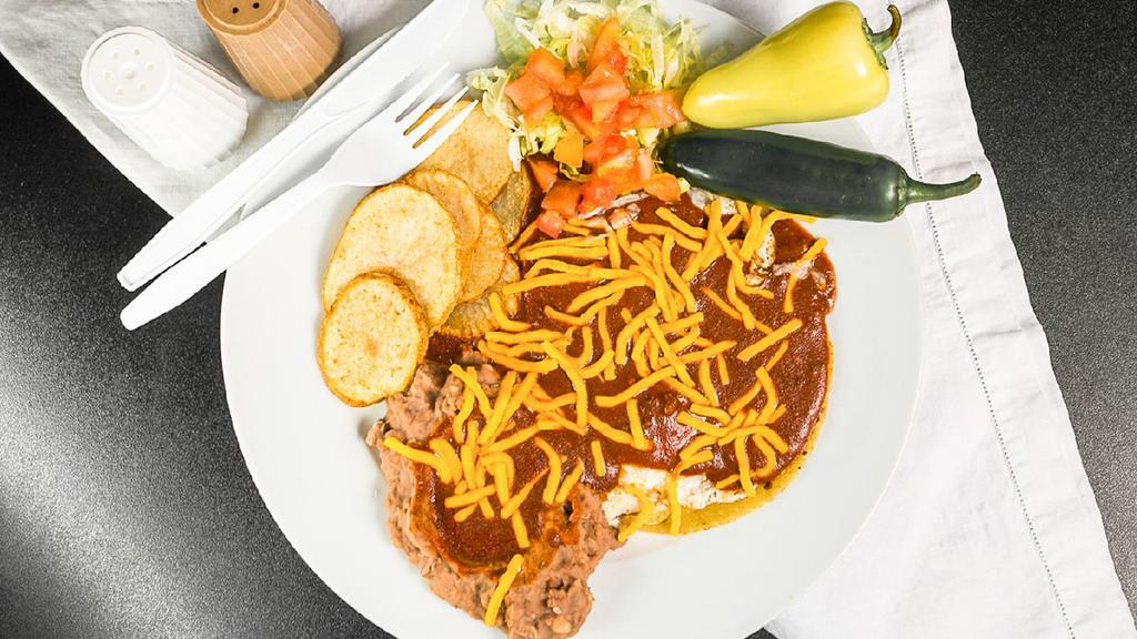 Huevos Rancheros · 2 eggs your way on 2 corn tortillas, refried beans, home fries, red or green chile, cheese, 2 plain sopaipillas and garnished with lettuce & tomatoes.
