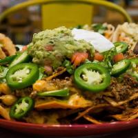 Loaded Nacho · House made tortilla chips layered with shredded cheese, pinto beans, and Chile con Queso, an...