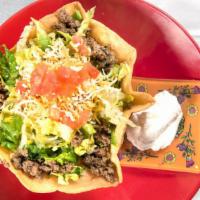 Taco Salad · Deep fried 10 inch flour tortilla with layers of beans, cheese and ground beef topped with l...