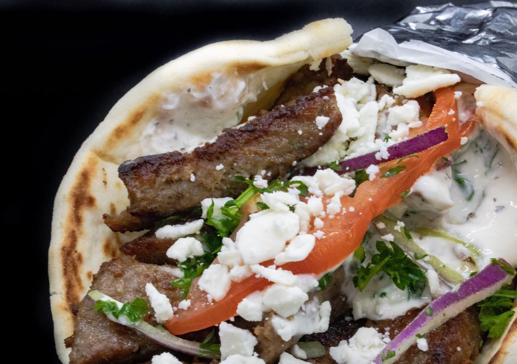 Super Gyro · Choice of lamb or chicken, served on Greek pita with house tzatziki, ﬁnished with tomato, onion and parsley. Larger pita with more meat and comes with feta cheese.