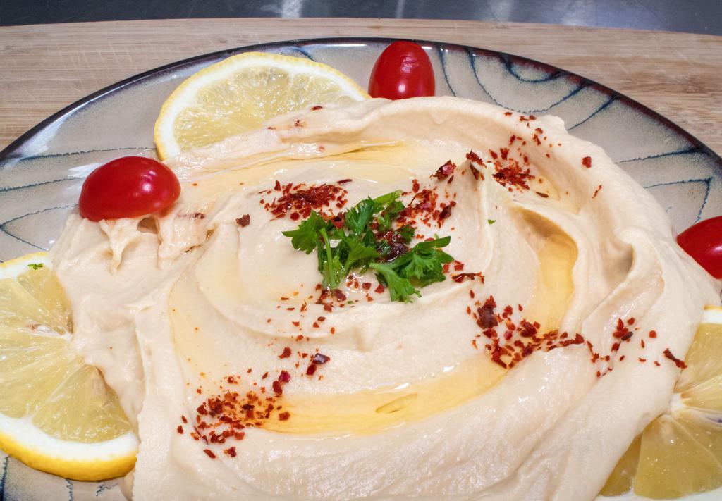 Hummus Plate · Garbanzo beans mashed with garlic, fresh lemon juice, and tahini sauce. Served with pita bread.
