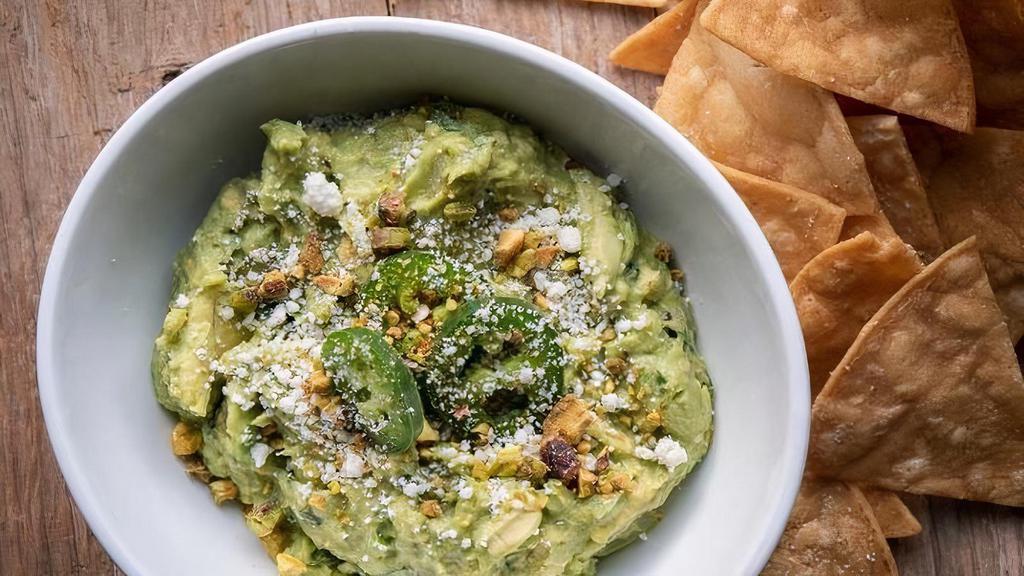 Chips And Guacamole · Guacamole with jalapeños, pistachios, cotija cheese, tortilla chips.