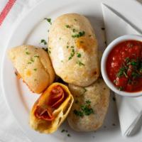Pepperoni Rolls · Brushed with garlic butter, filled with pepperoni, cheese blend and served with marinara.