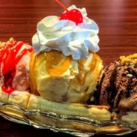 Banana Split · A scoop of vanilla, strawberry, and chocolate ice cream wedged between a split banana, toppe...