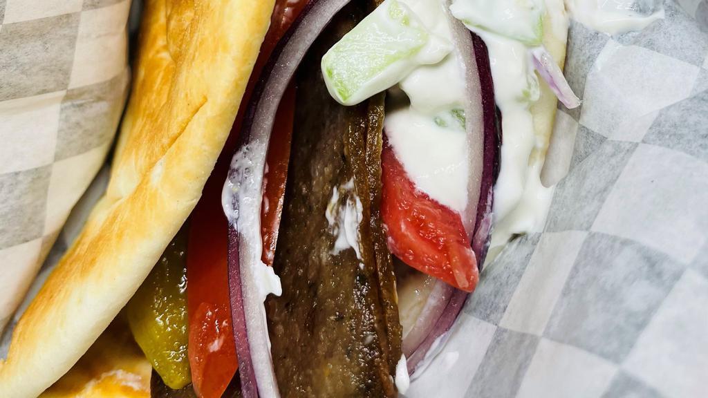 Gyro Sandwich · Lamb and Beef Gyro, Cucumber, Garlic Yogurt, Red Onions, Tomatoes, Pickles, and Turnip wrapped in Pita Bread.