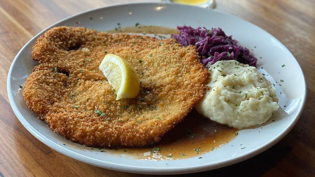 Chicken Schnitzel · Tender breaded chicken, served with Madeira sauce, fresh lemon, creamy mashed potatoes and homemade red cabbage.