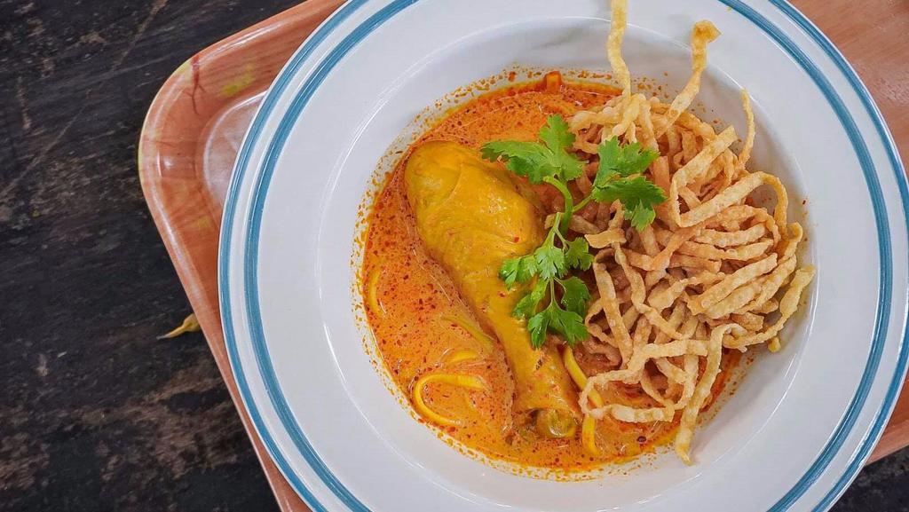 Khao Soi Gai · Egg noodle, chicken drumstick, yellow curry, bean sprout, shallot, crispy egg noodle and cilantro.