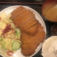 Tonkatsu · Japanese breaded deep - fried pork cutlet served with rice, miso, and salad.