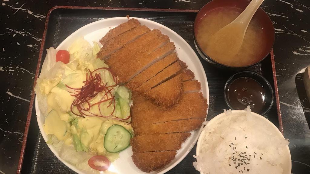 Tonkatsu · Japanese breaded deep - fried pork cutlet served with rice, miso, and salad.