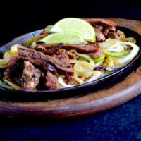 Steak Fajitas · Steak fajitas are served sizzling hot over a bed of sauteed onions and green peppers. Accomp...