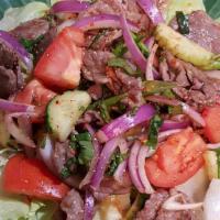 Yum Zabb Beef · Tossed with lime chili pepper vinaigrette, thai basil, tomato, onion and cucumber. Served on...