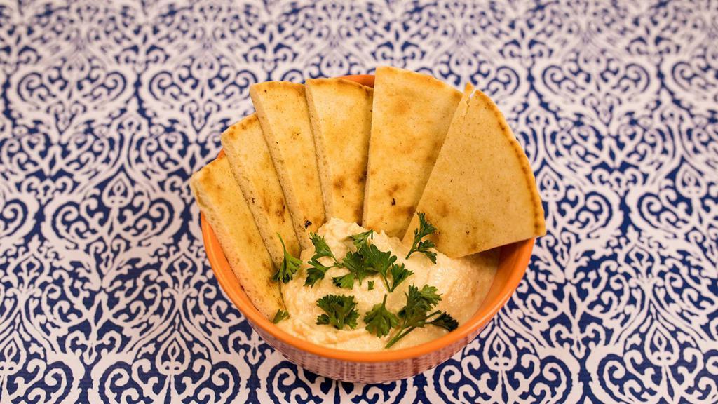 Hummus With Pita · Hummus Spread Made From Mashed Chickpeas, Tahini, Olive Oil, Lemon Juice, Salt & Garlic. Served w/ a Side of Pita Bread.