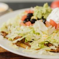 Tostada Supreme · A crisp tortilla covered with beans, lettuce, cheese, tomatoes, olives, sour cream, guacamol...