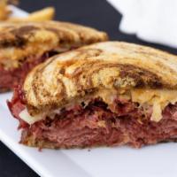 Reuben · Slow cooked corned beef served on marble rye with sauerkraut, Swiss cheese and house 1000 is...