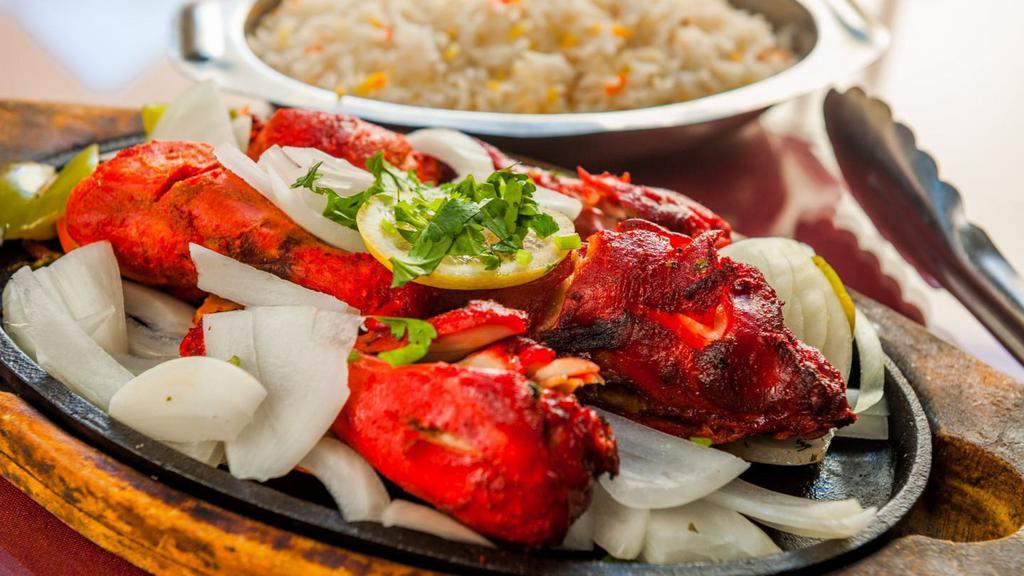 Chicken Tandoori · One half chicken marinated overnight in yogurt and very mild spices and barbecued in clay oven. Served with basmati rice.
