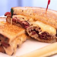 Classic Pastrami Reuben · Pastrami, Swiss, sauerkraut, and Russian dressing on our light rye; served with a pickle spear