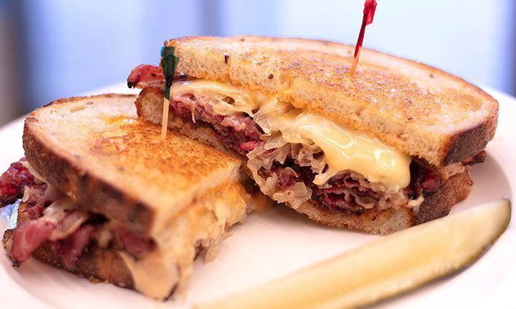 Classic Pastrami Reuben · Pastrami, Swiss, sauerkraut, and Russian dressing on our light rye; served with a pickle spear