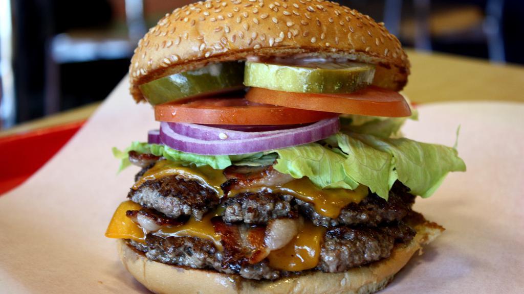 Double Cheeseburger · Two 1/3LB Hand-Made Lean USDA Beef, cheddar cheese, crisp lettuce, red ripe tomato slice, sliced red onions, hand-cut pickles and our Special Homemade sauce. Served on a toasted fresh baked sesame seed bun.