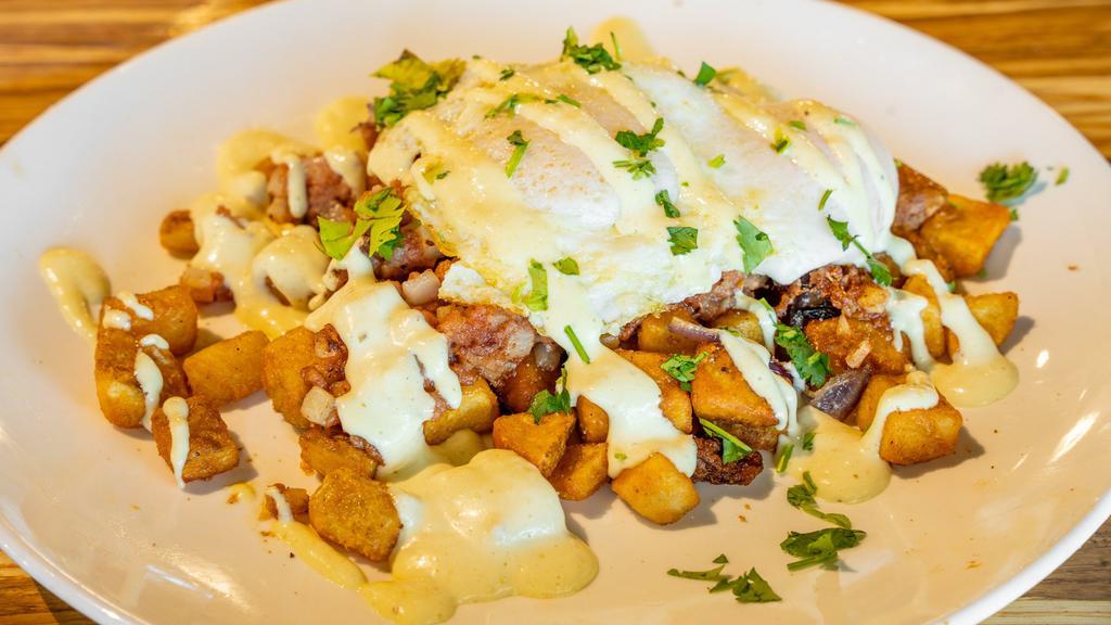 Carnitas Skillet · Seasoned potatoes, chicken carnitas, housemade green chili sauce, sautéed peppers, onion, queso, sour cream, sour cream, and (2) eggs. Served with a whole fire roasted jalapeño. Add shredded cheese for an additional charge.