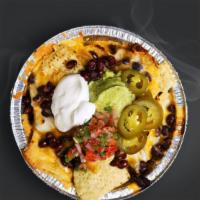 Nachos · Crispy tortilla chips and black beans together under a melty, cheesy blanket. Topped with gu...