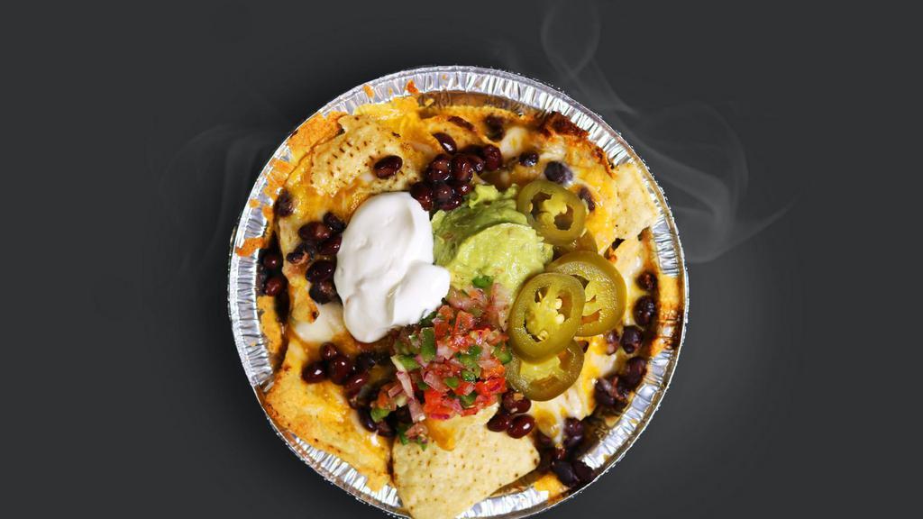 Nachos · Crispy tortilla chips and black beans together under a melty, cheesy blanket. Topped with guacamole, pico de Gallo and sour cream.