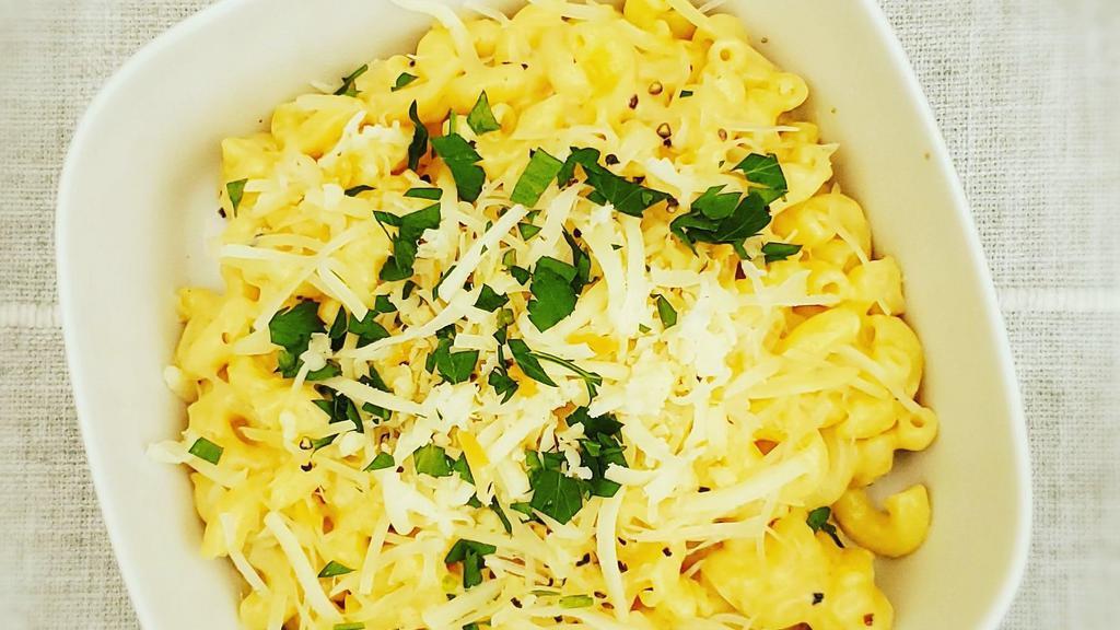 Mac And Cheese · Macaroni in a smoked Mozzarella and Parmesan cream sauce, topped with fresh herbs.
