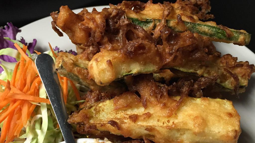 Coconut Zucchini: · Golden fried coconut-batter fresh zucchini served w/ spicy sour sauce and crushed peanuts.