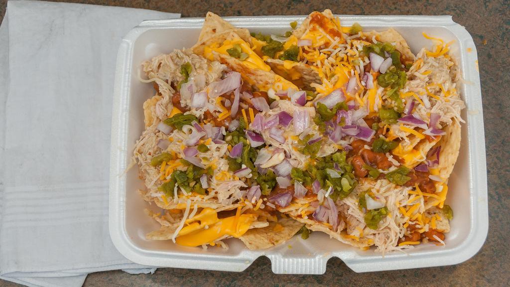 Nachos 1/2 · Corn tortilla chips with nacho cheese, pinto beans & sauce, any combination of meat salsa, onions or jalapeños.
